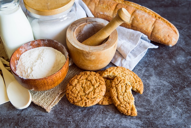 High angle of flour with cookies and bread