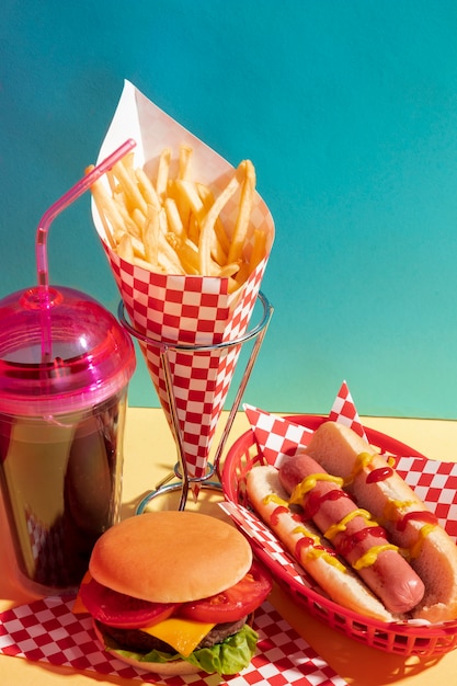 High angle food assortment with juice cup and cheeseburger