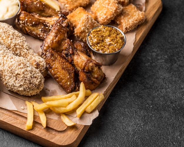 Free photo high angle of french fries with fried chicken and nuggets