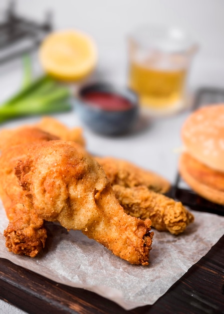 Free photo high angle fried chicken on cutting board with burger