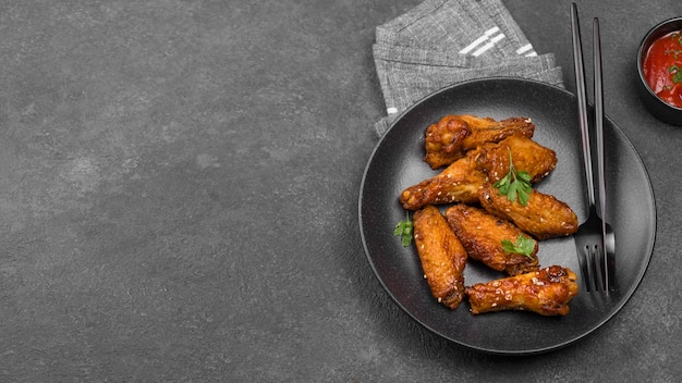 Free photo high angle of fried chicken on plate with sauce and copy space