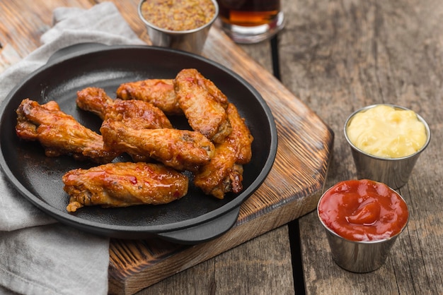 High angle of fried chicken on plate with variety of sauces and fizzy drink