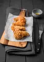 Free photo high angle fried chicken wings on cutting board