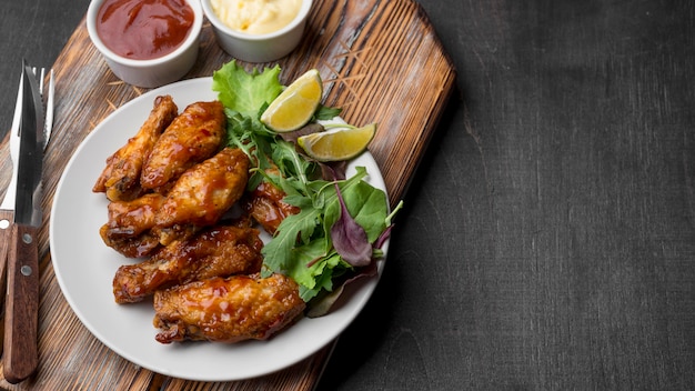 High angle of fried chicken with sauce and salad on plate