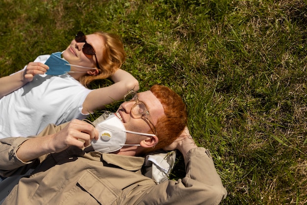 Free photo high angle friends laying on grass