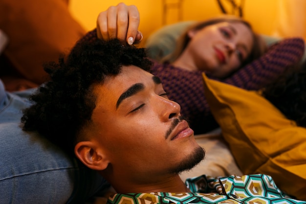 High angle friends sleeping in bed