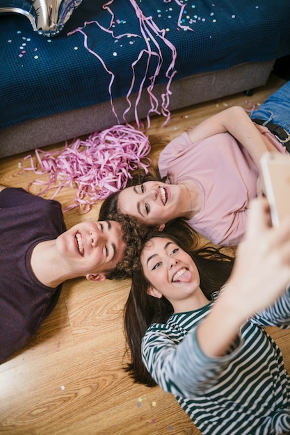 Free Photo high angle friends taking a selfie on the floor