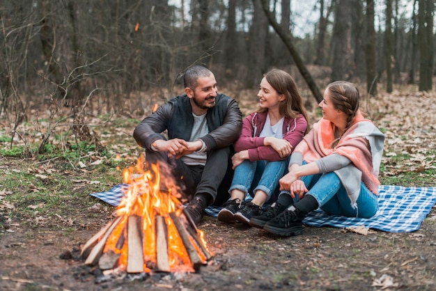 High angle friends talking at bonfire