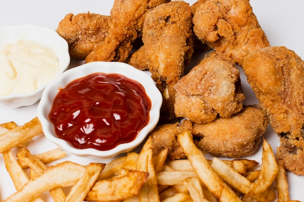 Free photo high angle of fries and fried chicken