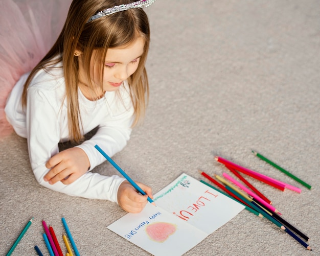 High angle of girl holding drawing card for father's day