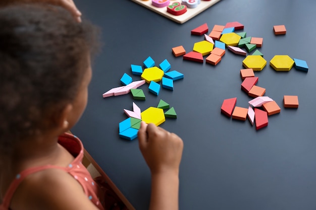 Free photo high angle girl making puzzle