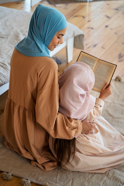 Free photo high angle girl and mother reading together