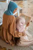 Free photo high angle girl and mother reading together