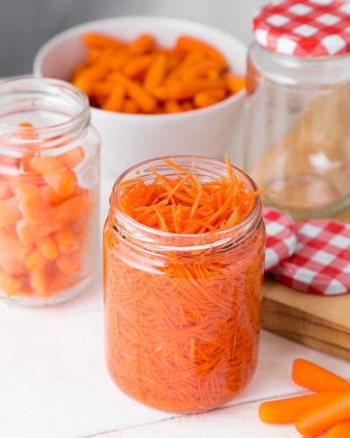 High angle of glass jar with chopped baby carrots