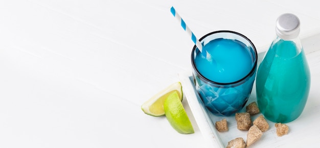 High angle of glass of soft drink with lime and bottle