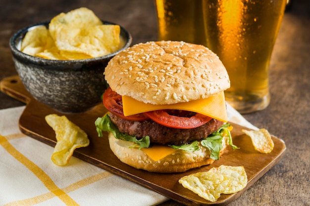 Free Photo high angle of glasses of beer with cheeseburger and potato chips