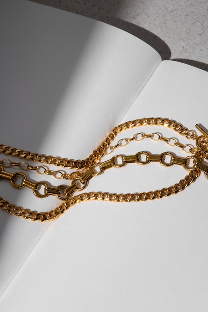 Free photo high angle gold chains on notebook