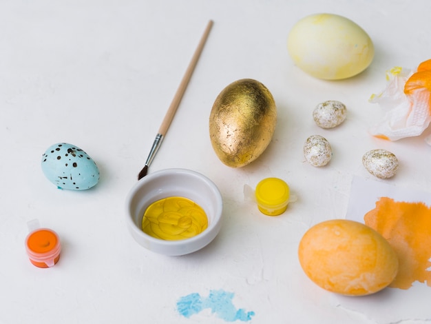 Free photo high angle of golden easter egg with dye and brush