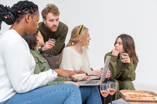 Free Photo high angle group of friends looking at laptop