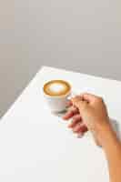 Free photo high angle hand holding coffee cup