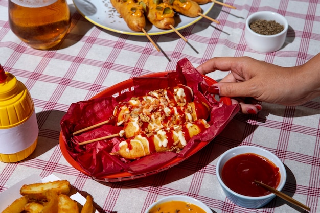 High angle hand holding corn dogs basket