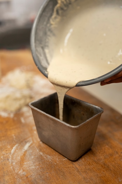 High angle hand pouring dough