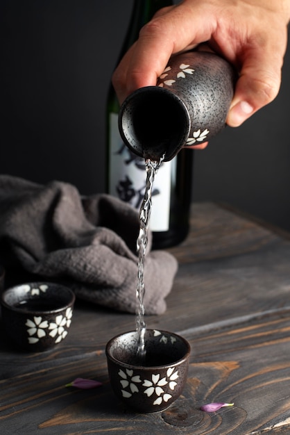 High angle hand pouring drink in cup