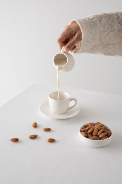 Free photo high angle hand pouring milk in cup