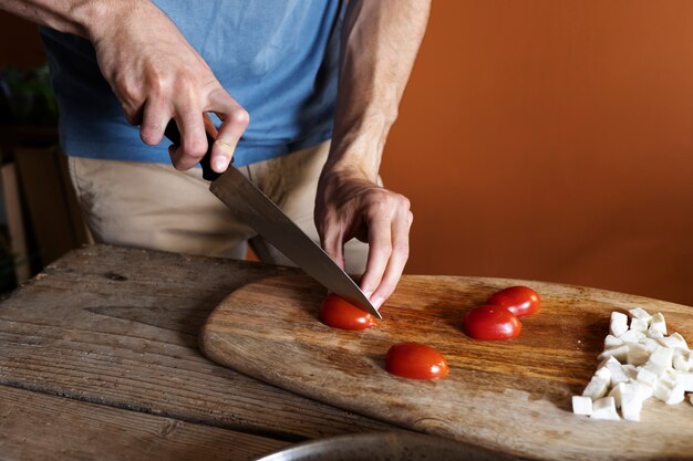 High angle hands cutting tomatoes