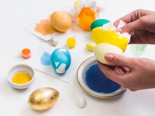 High angle of hands dyeing for easter holiday