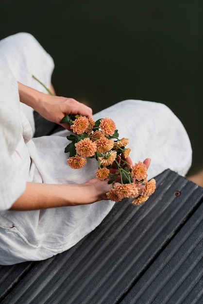 Free Photo high angle hands holding flowers