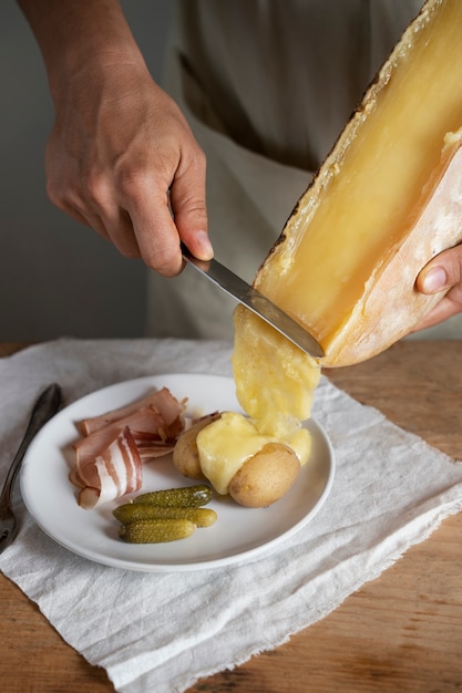 High angle hands putting melt cheese on food