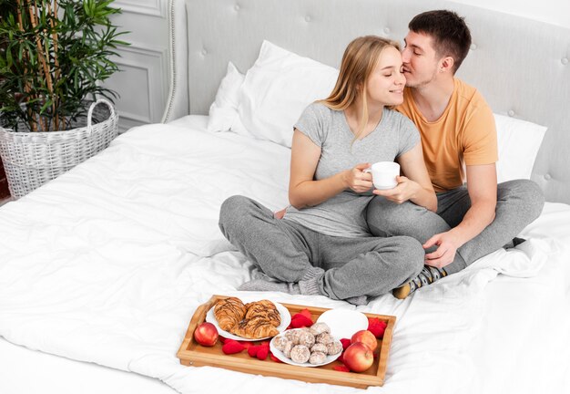 High angle happy couple with breakfast in bed