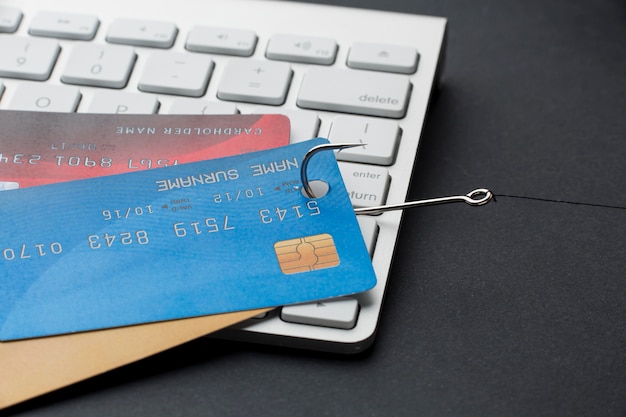 Free Photo high angle of keyboard with credit cards and hook for phishing