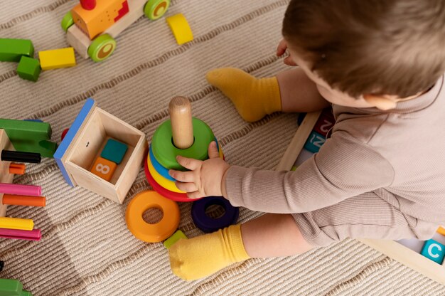 High angle kid playing with colorful toys