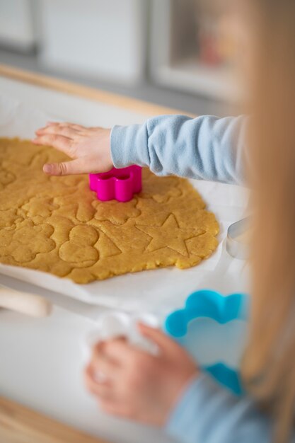 High angle kid using shape for baking