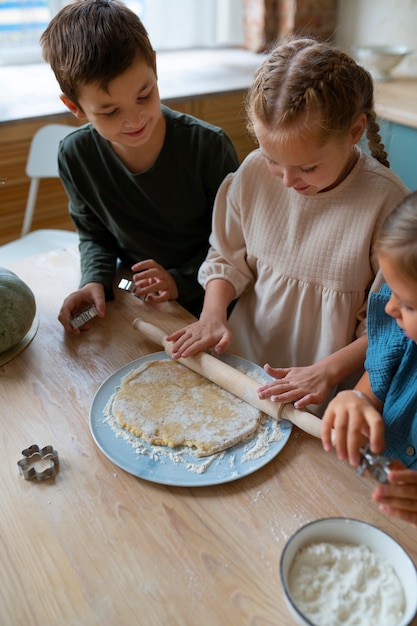 Free Photo high angle kids cooking together  indoors