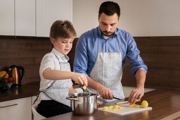 High angle little boy helping his dad to cook