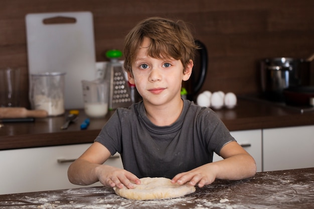 High angle little boy making dough