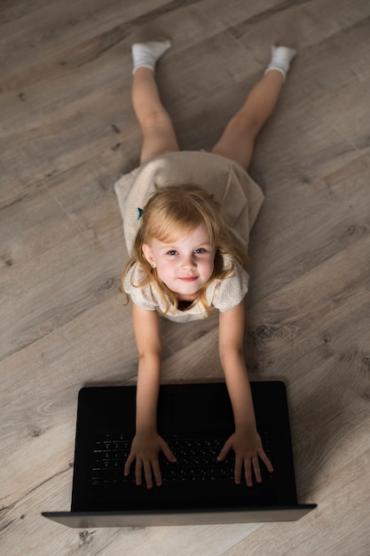 High angle little girl on floor looking at camera