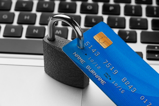 Free photo high angle of lock with credit card on top of laptop