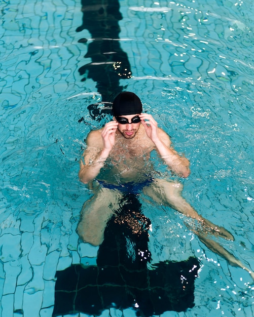 High angle male arranging swimming  goggles