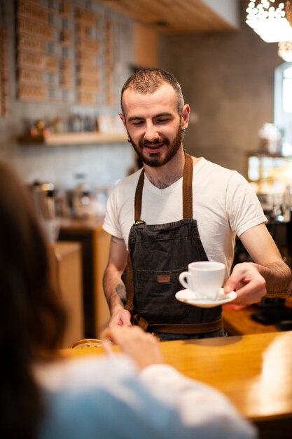 High angle male barista serving coffee