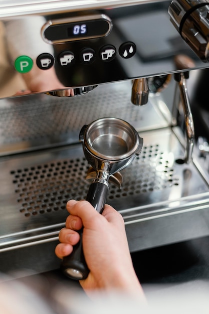 High angle of male barista using coffee machine