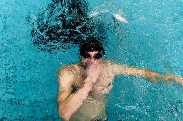 High angle male holding breath underwater