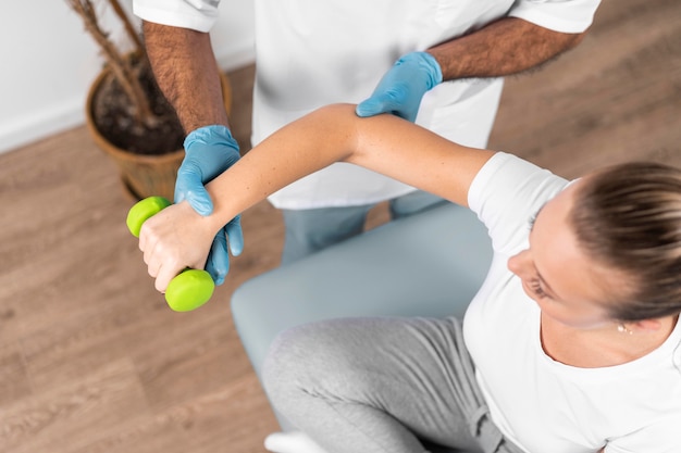 High angle of male physiotherapist checking woman's strength