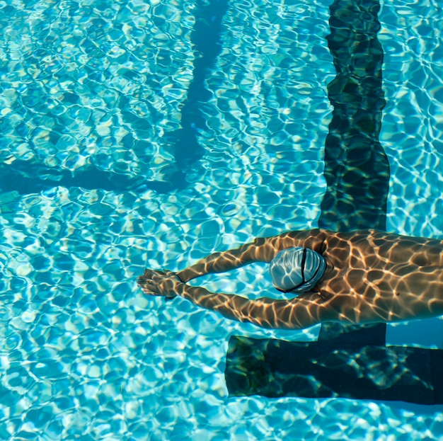 Free photo high angle of male swimmer swimming in water pool