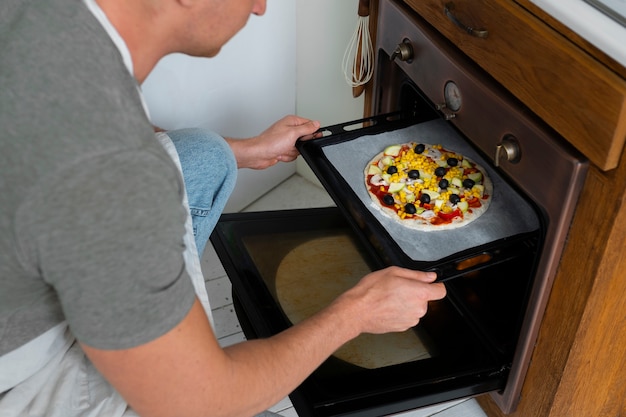 Free photo high angle man cooking pizza