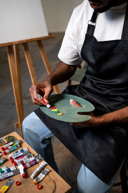 High angle man holding painting palette