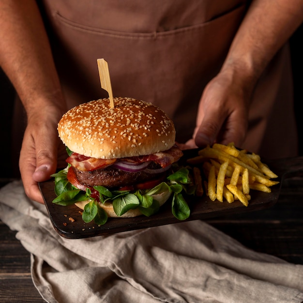 High angle man holding tray with burger and fries